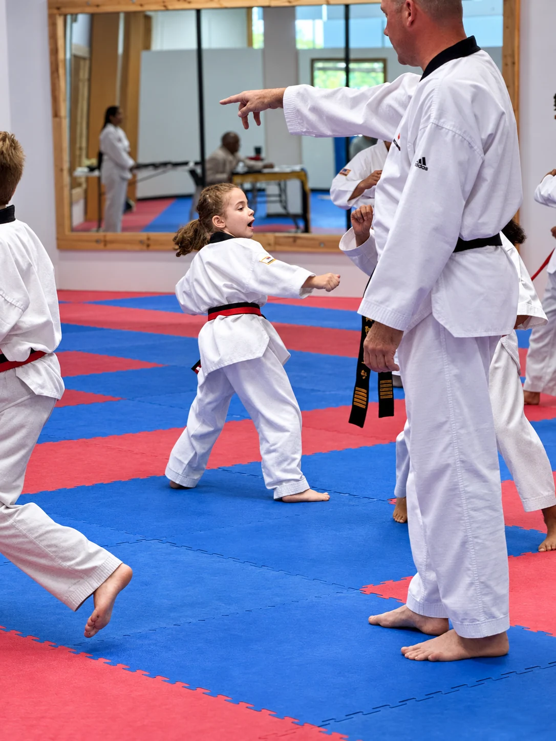 A student practices while an instructor guides a KTA class